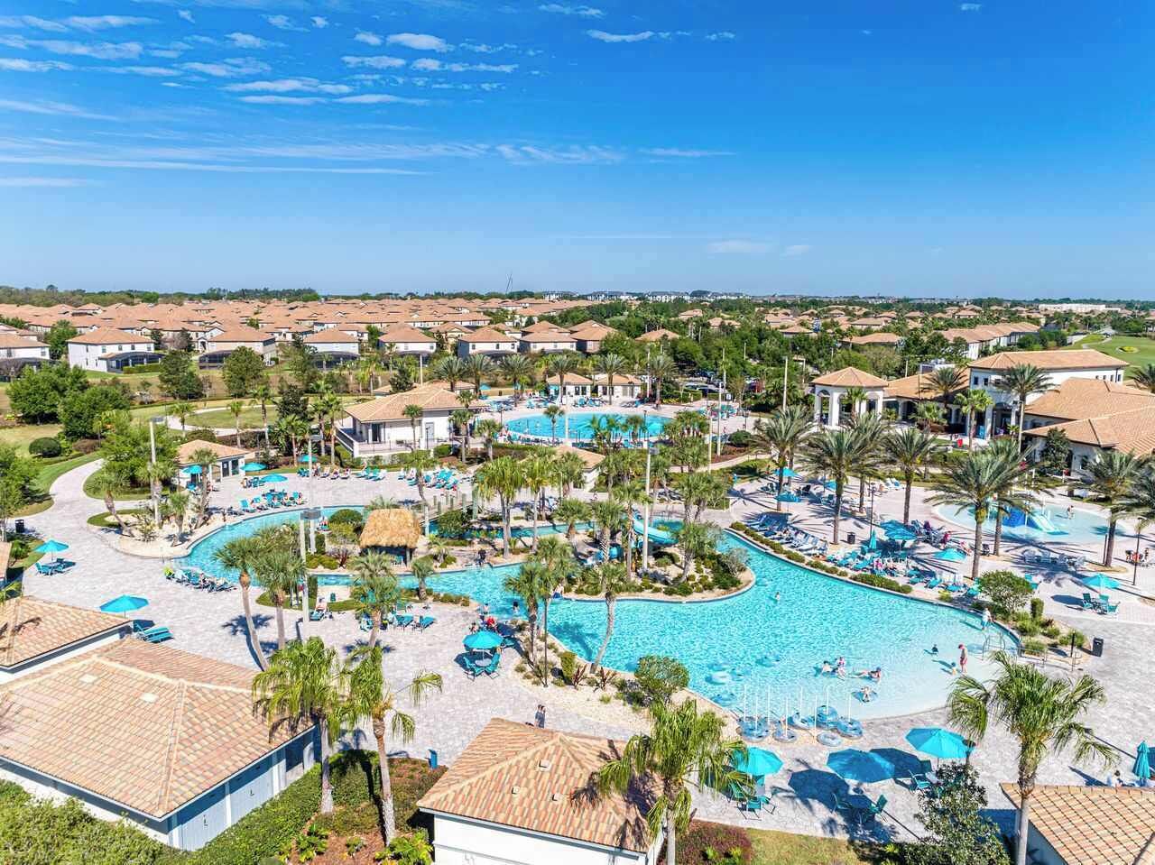 Ein Resort mit einem großen zentralen Pool, mehreren Liegebereichen und Blick auf die umliegende Nachbarschaft.