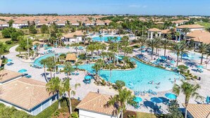Een resort met een groot centraal zwembad, diverse lounges en uitzicht op de omliggende buurt.