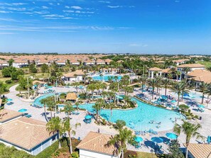 Ein Resort mit einem großen zentralen Pool, mehreren Liegebereichen und Blick auf die umliegende Nachbarschaft.