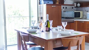 A kitchen with a dining table set for four, a microwave, an oven, and a window overlooking greenery. - Villino Boschetti—A terrace just 15 minutes from the beach in Vasto (Abruzzo)
