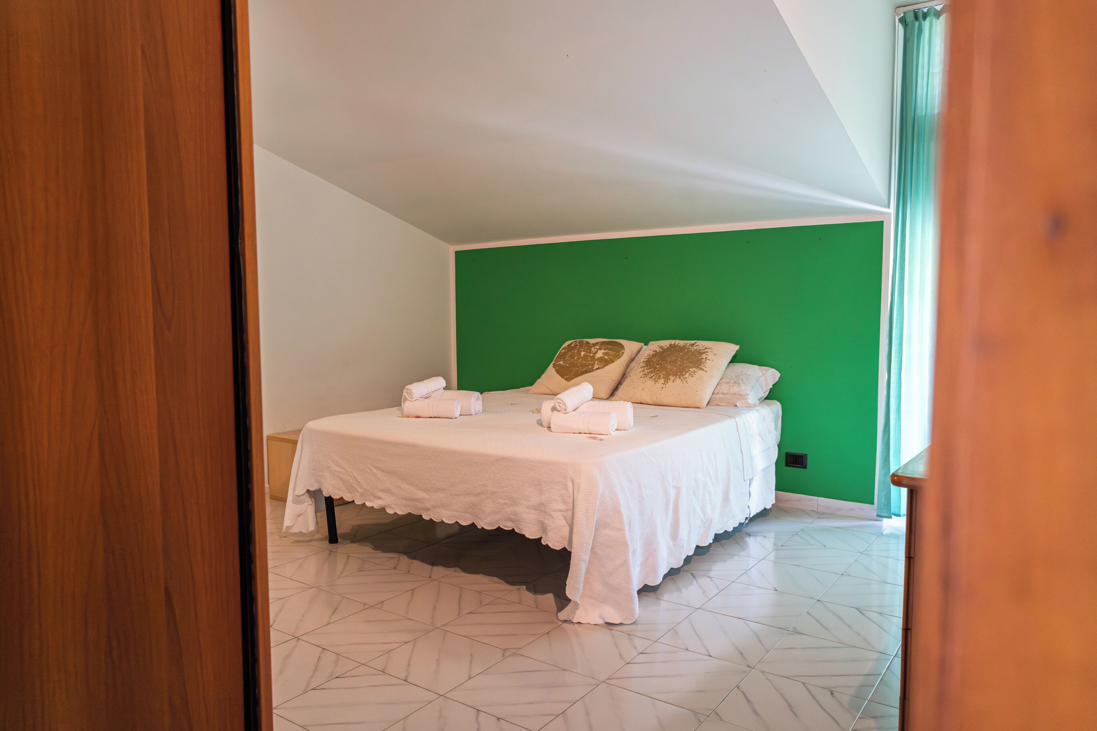 Ein Schlafzimmer mit einem Bett, Kissen und Handtüchern.