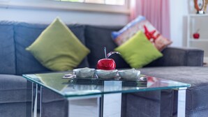 A modern living room with a glass coffee table, a red apple, and decorative bowls. - Villino Boschetti—A terrace just 15 minutes from the beach in Vasto (Abruzzo)