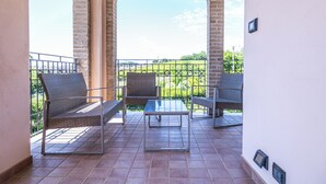 A balcony with wicker chairs, a table, and a view of a green landscape. - Villino Boschetti—A terrace just 15 minutes from the beach in Vasto (Abruzzo)