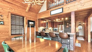 Un interior de madera con comedor, cocina y una escalera.