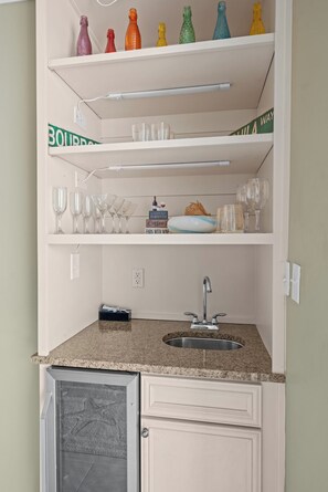 A compact kitchen with a built-in sink, a microwave, and a small refrigerator. -  One of The Wharf's Newest Vacation Rentals. (Orange Beach)