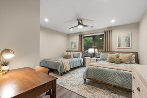 A bedroom with two beds, a desk, a chair, a ceiling fan, and artwork on the walls. - Pool, Hot Tub, Sauna, Game Room, Luxury and More! (Albrightsville)