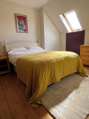 A bedroom with a bed, a nightstand, a dresser, a window, and a painting on the wall. - Beautiful 4 bed/3bath house in Barnes, South West London by the Thames (London)