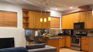 A modern kitchen with wooden cabinets, a built-in microwave, and a stainless steel oven. - Serene 2-bedroom apartment in Tukwila perfect for your stay (Tukwila)