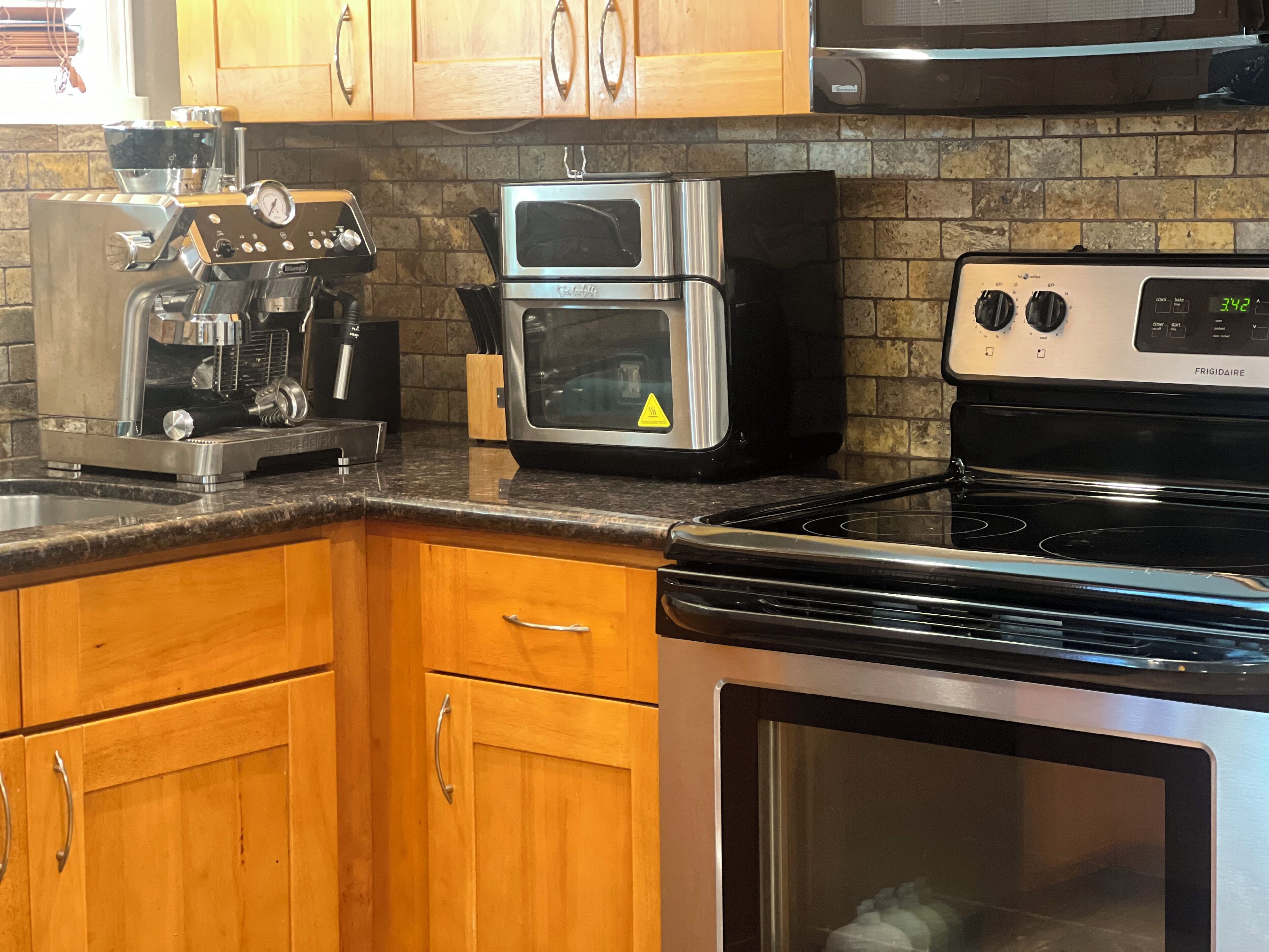 A kitchen with a coffee maker, toaster oven, and stove.