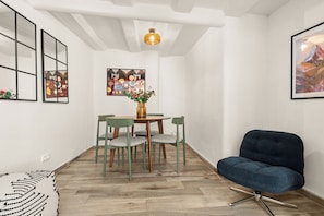 A dining area with a wooden table and chairs, a vase with flowers, and artwork on the walls. - COUNT'S HOUSE – Historic half-timbered house – Central location, PS5+Switch, BBQ (Korbach)