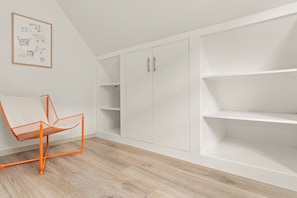 A room with a white wardrobe, a chair, and a framed picture on the wall. - COUNT'S HOUSE – Historic half-timbered house – Central location, PS5+Switch, BBQ (Korbach)