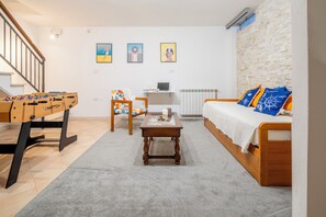 A living room with a foosball table, a sofa with patterned cushions, a coffee table, and a computer desk. - A Tuscan Gem | Family Home with 2 Gardens & Private Parking (Viareggio)