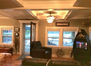 Un salon avec une cheminée, un téléviseur et une vue sur la terrasse extérieure.