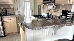 Een koffiezetapparaat/waterkoker, een koelkast, een magnetron, een oven