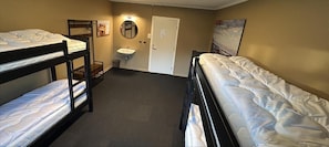 A room with bunk beds, a sink, and a door. - Stayover Lista (Farsund)