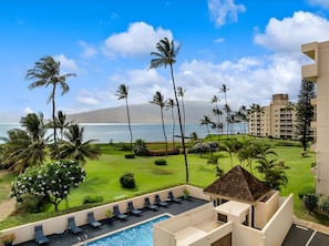 A resort with a pool, lounge chairs, palm trees, and a view of the ocean. - Beachfront 4BR, 2 Condos for 12 in Kihei, Hawaii! (Kihei)