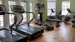A fitness center with treadmills, elliptical machines, and stationary bikes. - 7 Bedroom Villa Near Disney World – Pool & Spa, Kissimmee (Kissimmee)