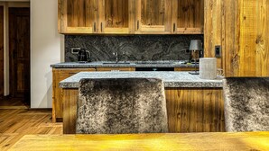 Une cuisine avec des armoires en bois, des comptoirs en granit et un îlot central intégré.
