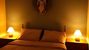 A bedroom with a bed, two bedside tables, and a wall-mounted decoration. - SHB Chácara para Eventos com Piscina (Elias Fausto)