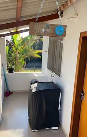 A small, enclosed bathroom with a window, a sink, and a mirror.