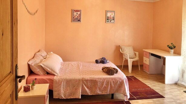 A bedroom with a bed, a desk, a chair, and two wall posters. - Stunning Beachfront Apartment Just 3 Minutes from Sidi Fredj Beach (Staoueli)
