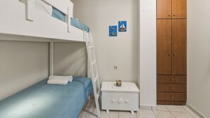 A bunk bed room with a white nightstand, a wooden wardrobe, and two wall decorations. - Aeriko Villa with Private pool - Where mountains meet the sea (Heraklion)