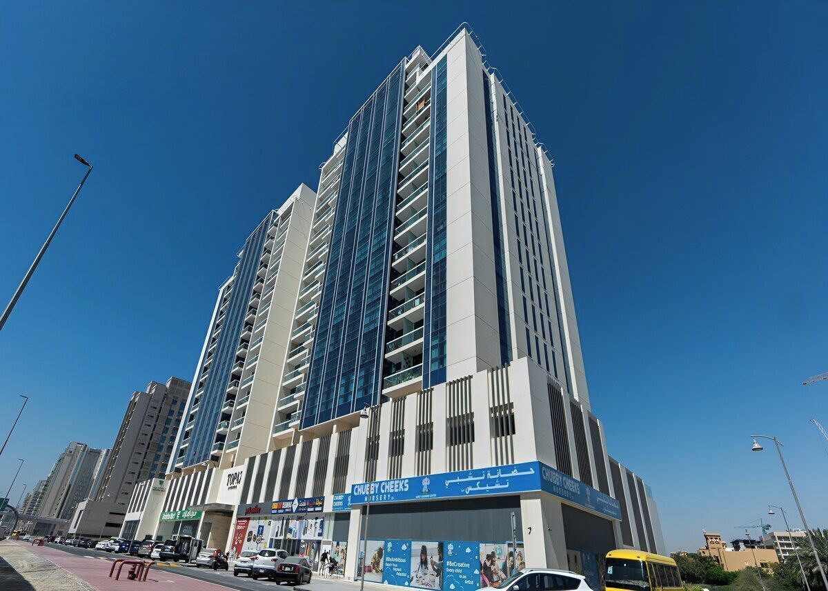 A tall hotel with multiple floors, a prominent sign for 'Chubby Cheeks', and a clear blue sky in the background.