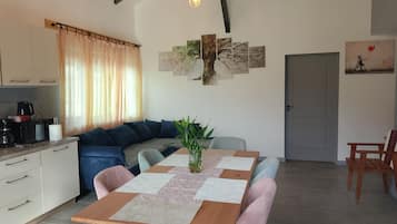 Eine moderne Küche mit Essbereich, ausgestattet mit einem Holztisch, Stühlen und einer Couch.