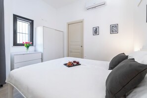 A bedroom with a bed, a window with flowers, a door, and two framed pictures on the wall. - [5 min from the M1 subway] Private Suite - CityLife (Milano)