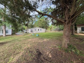 A residential property with a detached house, a large tree, and a well-maintained lawn. - 3-bedroom house in beautiful Cove point Beach! Just a short walk from the beach (Lusby)
