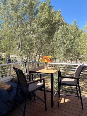 An outdoor deck with a table and chairs, a metal railing, and a view of trees and a mountain. - "Frisco Mountain Retreat 3BR/3BA, Sleeps 7 — Steps from Slopes & Summer Trails" (Frisco)