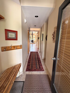 A hallway with a bench, a patterned rug, and a door with blinds. - "Frisco Mountain Retreat 3BR/3BA, Sleeps 7 — Steps from Slopes & Summer Trails" (Frisco)