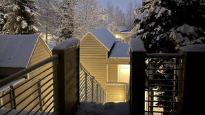 A snow-covered wooden cabin with a metal gate and railing, surrounded by trees. - "Frisco Mountain Retreat 3BR/3BA, Sleeps 7 — Steps from Slopes & Summer Trails" (Frisco)