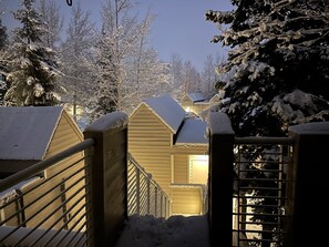 A snow-covered wooden cabin with a metal gate and railing, surrounded by trees. - "Frisco Mountain Retreat 3BR/3BA, Sleeps 7 — Steps from Slopes & Summer Trails" (Frisco)