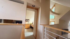 A staircase with a wooden handrail leading to a bedroom with a bed, a nightstand, and a lamp. - "Frisco Mountain Retreat 3BR/3BA, Sleeps 7 — Steps from Slopes & Summer Trails" (Frisco)