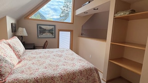 A bedroom with a bed, a desk, a chair, a window with a mountain view, and a built-in shelf. - "Frisco Mountain Retreat 3BR/3BA, Sleeps 7 — Steps from Slopes & Summer Trails" (Frisco)