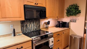 A kitchen with wooden cabinets, a stainless steel stove, a microwave, and a coffee maker. - "Frisco Mountain Retreat 3BR/3BA, Sleeps 7 — Steps from Slopes & Summer Trails" (Frisco)