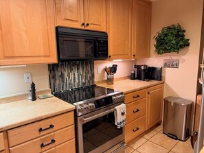 A kitchen with wooden cabinets, a stainless steel stove, a microwave, and a coffee maker. - "Frisco Mountain Retreat 3BR/3BA, Sleeps 7 — Steps from Slopes & Summer Trails" (Frisco)