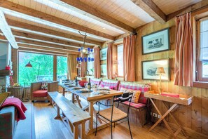 A rustic wooden interior with a long dining table, benches, and a bench seating area. - Praz de la Legettaz C & D – Stunning Duplex with Panoramic Views (Val-d'Isère)