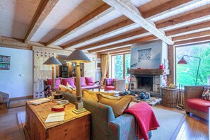 A cozy living room with wooden beams, a fireplace, and colorful furnishings. - Praz de la Legettaz C & D – Stunning Duplex with Panoramic Views (Val-d'Isère)