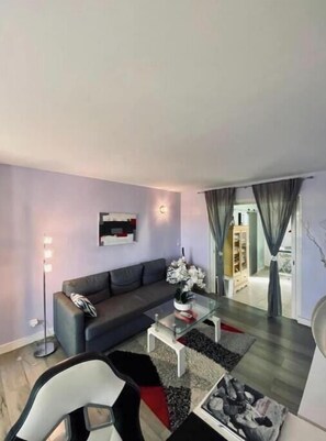 Ein modernes Wohnzimmer mit Sofa, Couchtisch und Glastrennwand.