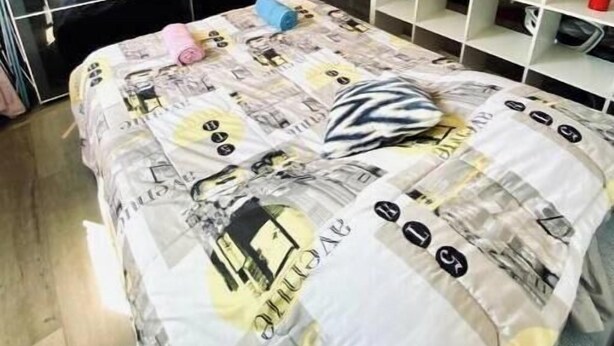 Un dormitorio con cama, armario y estantería blanca.