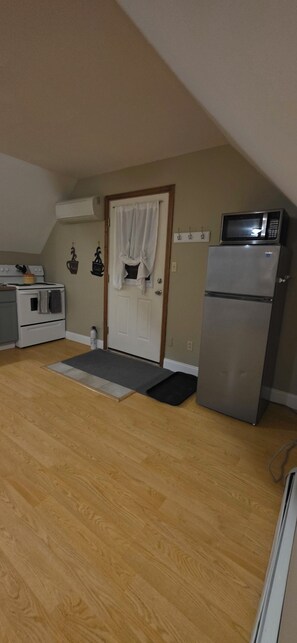 A kitchen with a microwave, refrigerator, stove, and oven. - Serene studio in Swanton perfect for a relaxing home away from home. (Swanton)