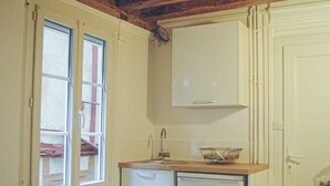 Eine Küche mit Holzbalken, einem weißen Kühlschrank, einer Spüle und einer Arbeitsfläche.