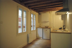 A compact kitchen with a built-in refrigerator, a small sink, and a countertop. - Dijon Standing Historic City Apartment (Dijon)