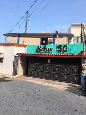 Ein Gebäude mit einem Schild, auf dem 'Bahia 50' steht, und einer schwarzen Garagenöffnung.