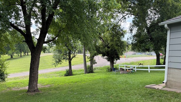 A grassy area with trees and a white fence. - 4-BR2-BA House INSIDE Iowa State fair! With jetted tub for 2 (Des Moines)