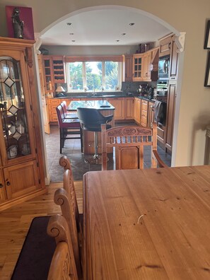 A kitchen with wooden cabinets, a dining table, and a bar area. - Golf enthusiasts- Gorgeous 4bedroom house in charming countryside. (Dromhane)