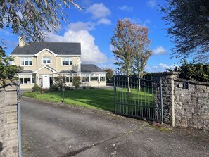 A two-story house with a gated driveway and a stone wall. - Golf enthusiasts- Gorgeous 4bedroom house in charming countryside. (Dromhane)