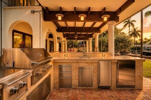 An outdoor kitchen with a stainless steel grill, built-in appliances, and a pergola overhead. - Hideaway & Harbour -2 minute walk to the beach (Fort Lauderdale)